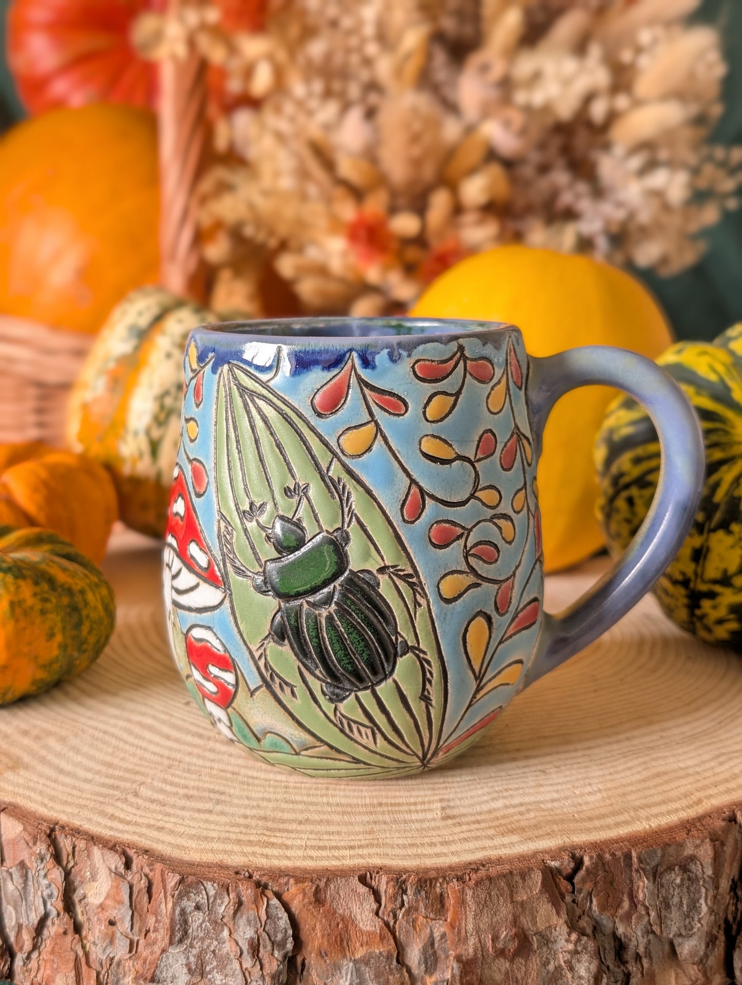 Whimsical handcrafted forest-themed mugs with earthy glazes and intricate carvings inspired by beetles