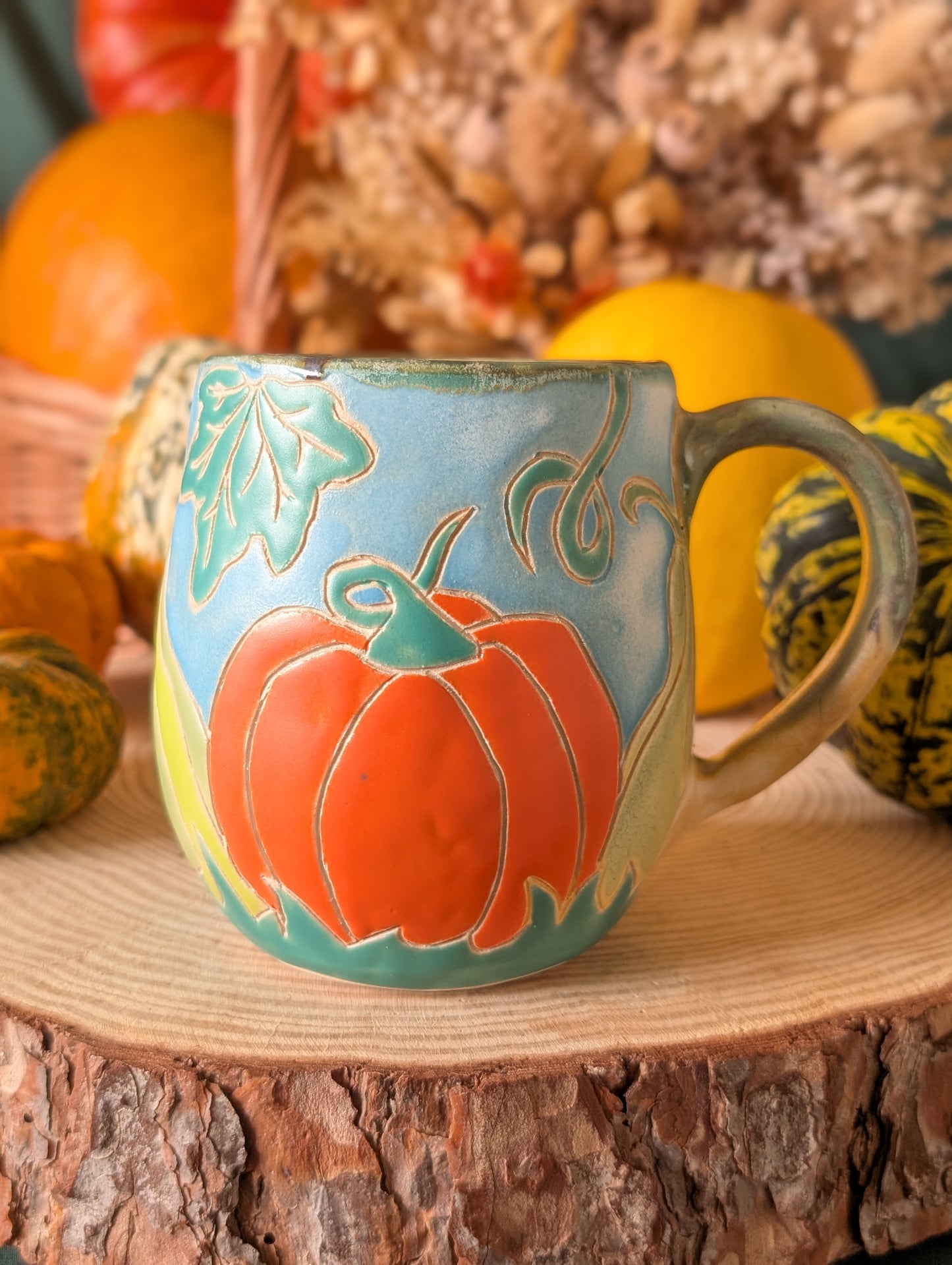 Cozy pumpkin spice-inspired ceramic mugs in orange, gold, and green hues, ideal for fall tea or lattes