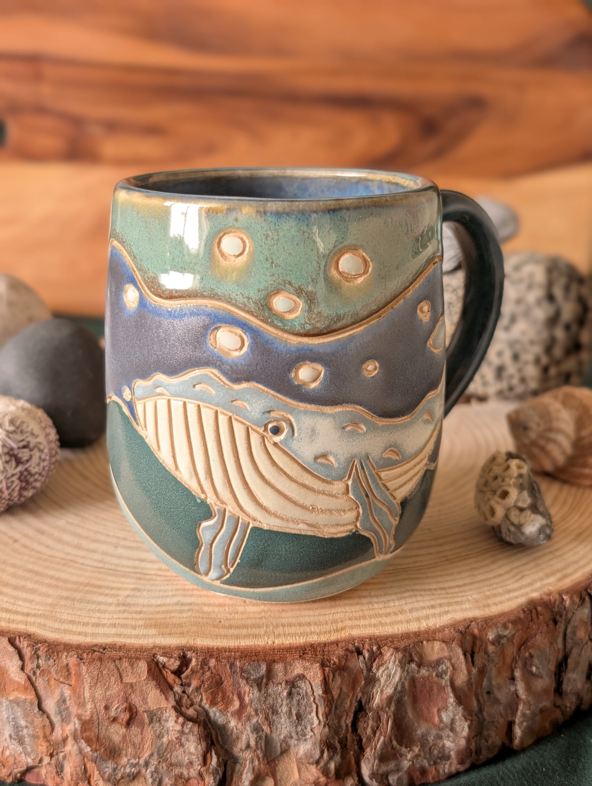Unique ocean-inspired pottery mug featuring carved whale design in blue ceramic