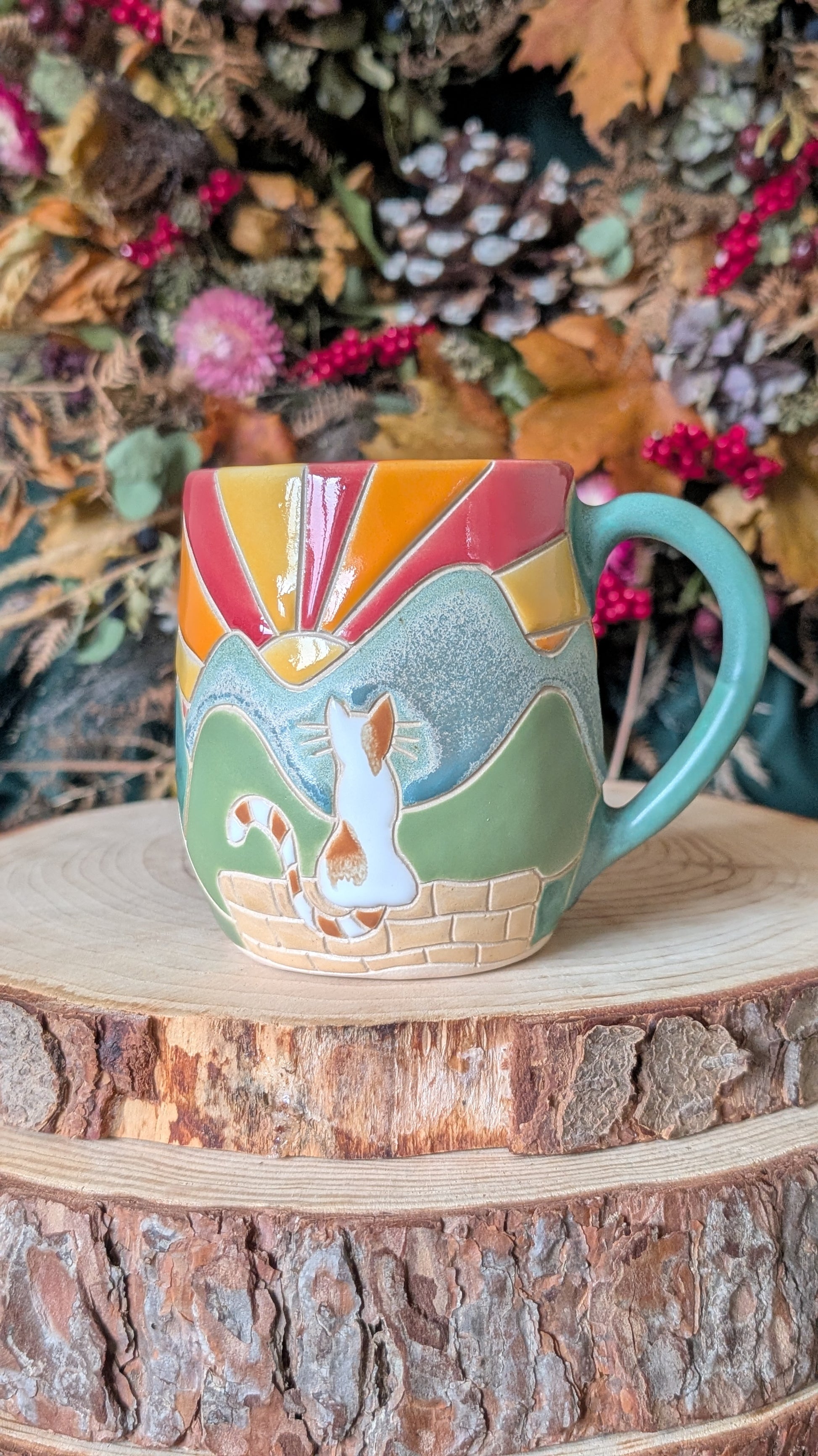 Handmade ceramic mug featuring a hand-carved and hand-painted cat design inspired by the countryside.